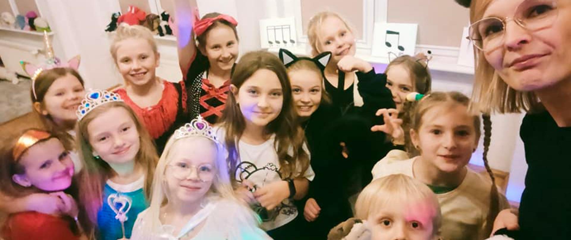 Zdjęcie przedstawia dzieci poprzebierane na kolorowo z okazji andrzejkowego spotkania. Dzieci są uśmiechnięte. 