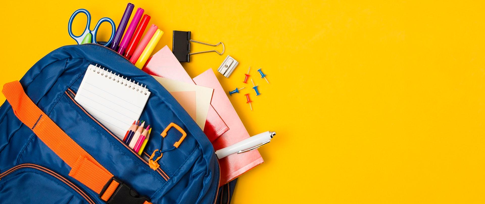 zdjęcie przedstawiające plecak z rozsypującymi się przyborami szkolnymi