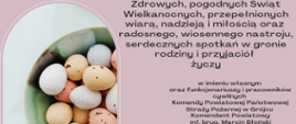 Kartka wielkanocna na jasnoróżowym tle. Po lewej stronie znajduje się okrągłe zdjęcie miski w odcieniach zieleni, wypełnionej pastelowymi jajkami (białe, kremowe, żółte i jasnoróżowe), niektóre w drobne kropki.
Po prawej stronie widoczny jest tekst w języku polskim:
„Zdrowych, pogodnych Świąt Wielkanocnych, przepełnionych wiarą, nadzieją i miłością oraz radosnego, wiosennego nastroju, serdecznych spotkań w gronie rodziny i przyjaciół życzy
w imieniu własnym oraz funkcjonariuszy i pracowników cywilnych
Komendy Powiatowej Państwowej Straży Pożarnej w Grójcu
Komendant Powiatowy
mł. bryg. Marcin Błoński”.
Na dole po prawej stronie znajduje się logo Państwowej Straży Pożarnej – herb z orłem w środku, otoczony złotymi elementami i czerwonym płomieniem u góry.
Całość ma spokojny, świąteczny i wiosenny charakter.
