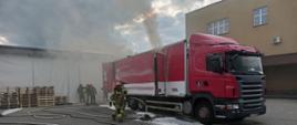 Dymy wydobywające się z ciężarówki a obok strażacy