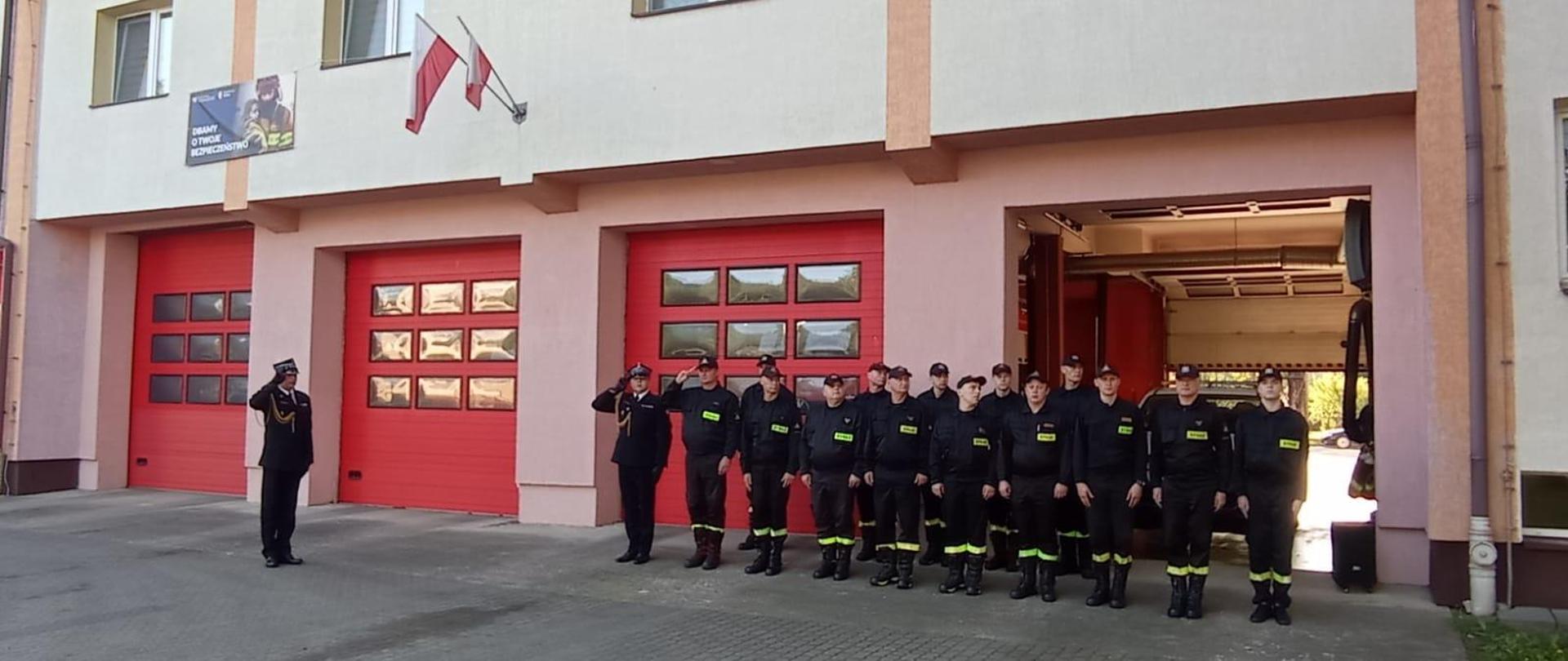 Na zdjęciu widoczni strażacy podczas uroczystej zmiany służby z okazji Dnia Flagi. 