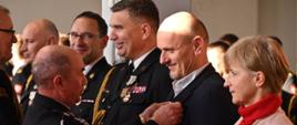 Komendant Powiatowy PSP w Wodzisławiu Śląskim oraz Prezes Zarządu Oddziału Powiatowego PSP w Wodzisławiu Śląskim wręczają odznaki "Prezes Zarządu Oddziału Powiatowego ZOSP RP druh Zbigniew Radecki oraz Komendant Powiatowy PSP w Wodzisławiu Śląskim st. bryg. Marek Misiura wręczają odznaki „Zasłużony dla ochrony przeciwpożarowej powiatu wodzisławskiego”