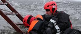 Zdjęcie przedstawia ćwiczących strażaków podczas ćwiczeń na lodzie