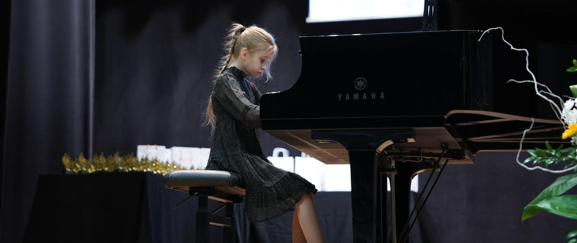 Uczennica grająca na fortepianie w sali koncertowej w Libiążu
