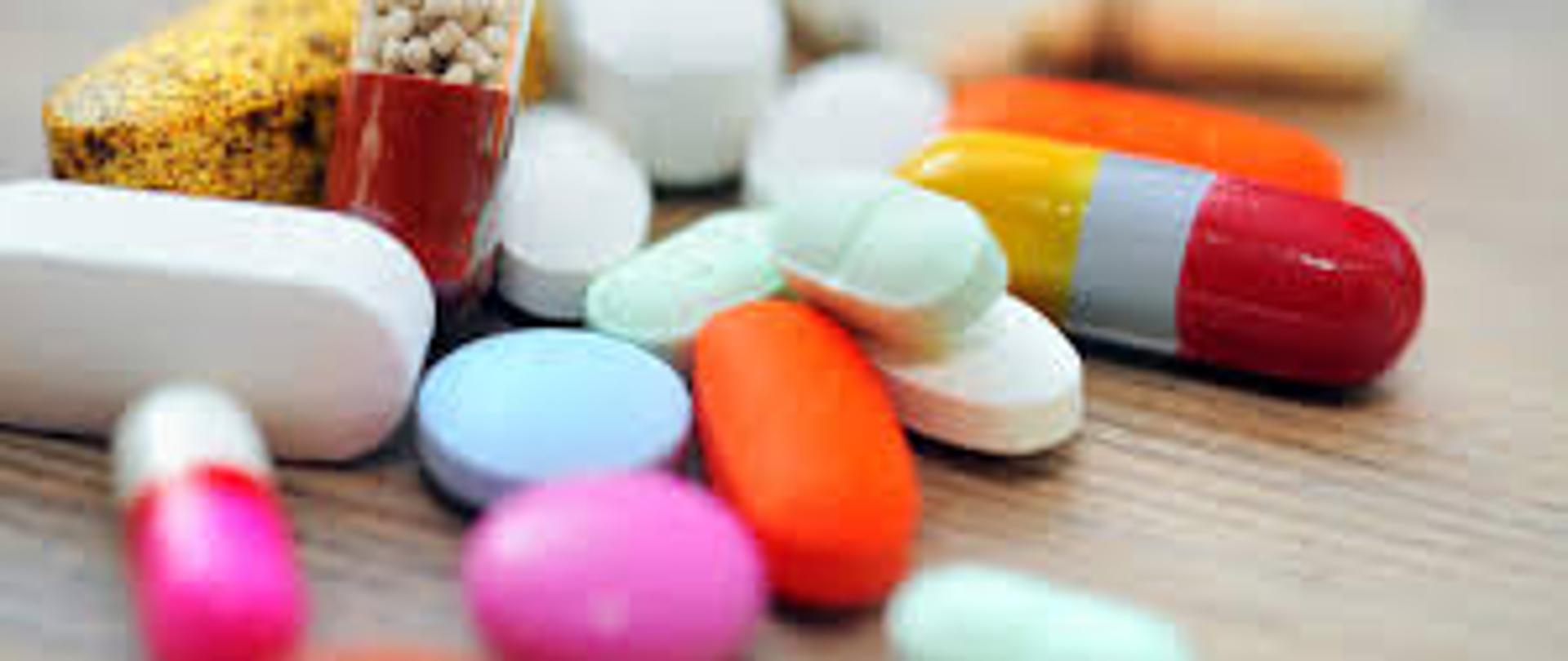 kolorowe tabletki rozrzucone na drewnianym blacie