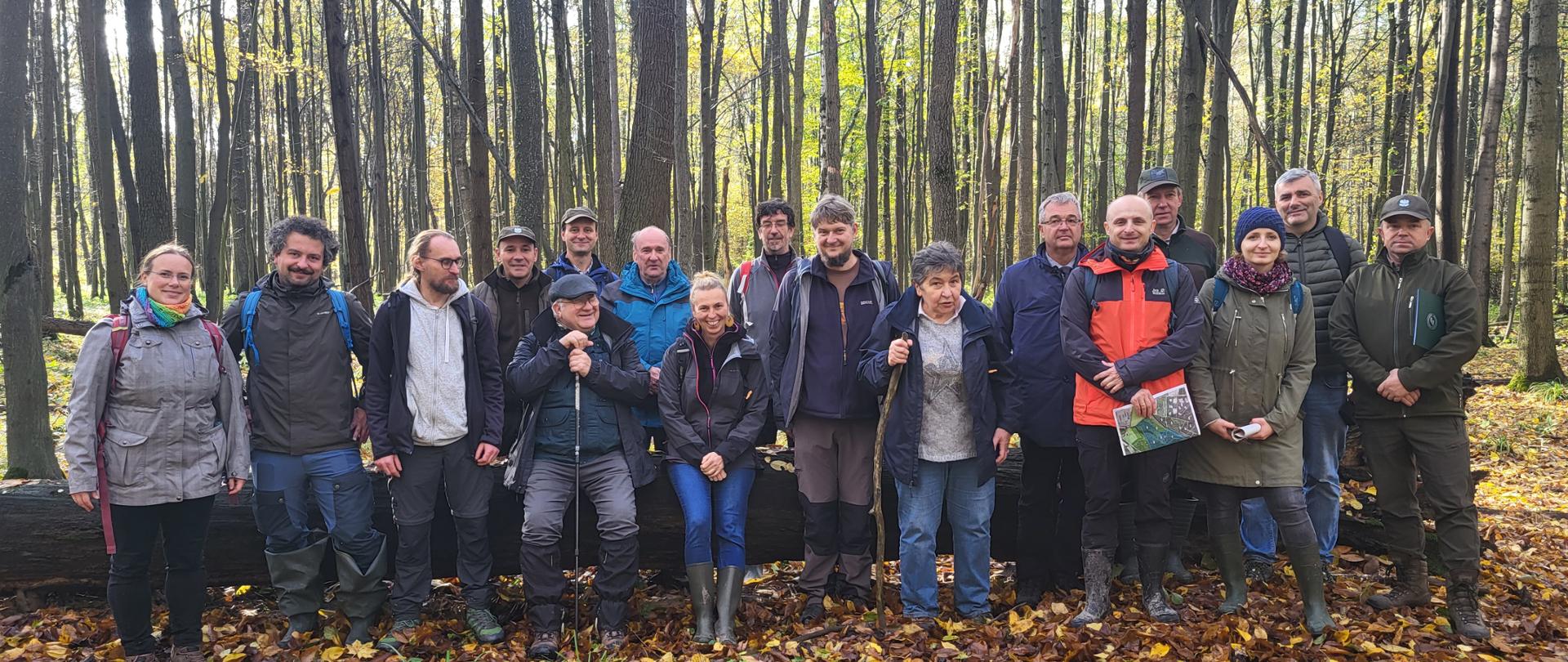 Grupa ludzi pozująca do fotografii w lesie