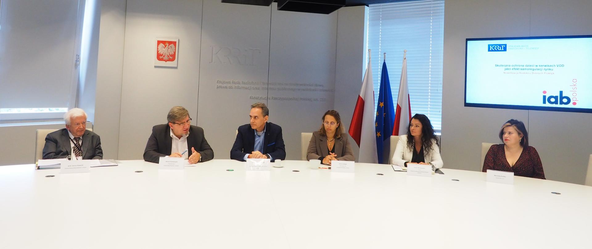 Uczestnicy konferencji siedzący za stołem 