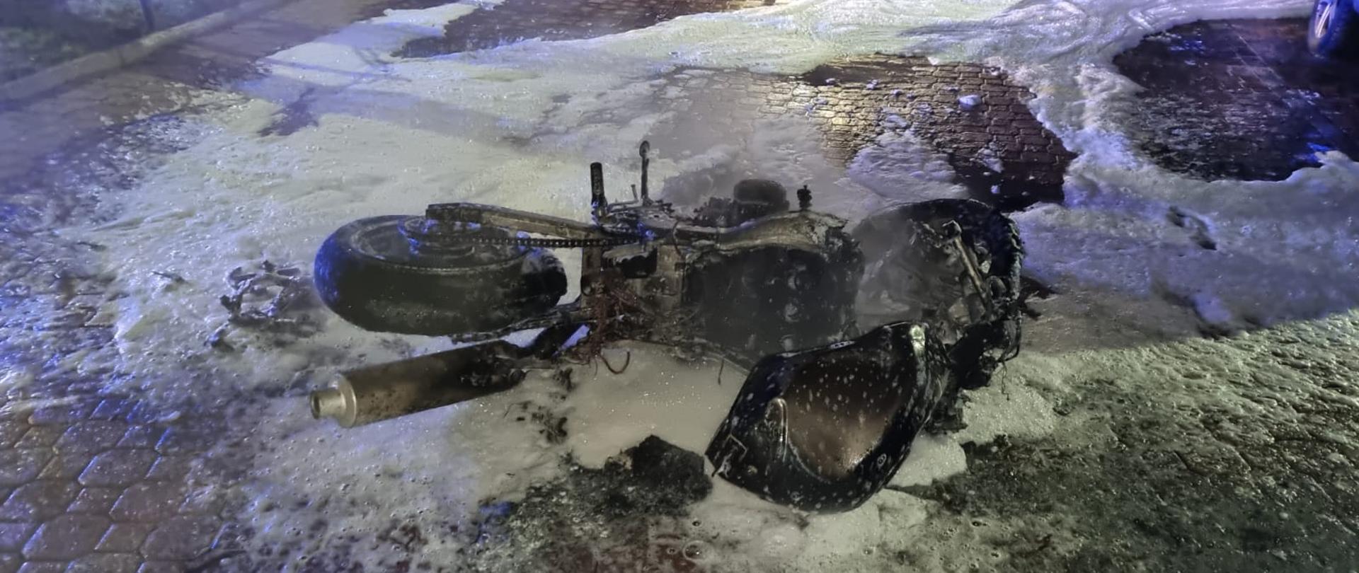 Motocykl leżący na ziemi pokryty pianą