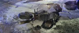 Spalony motocykl leży pokryty pianą