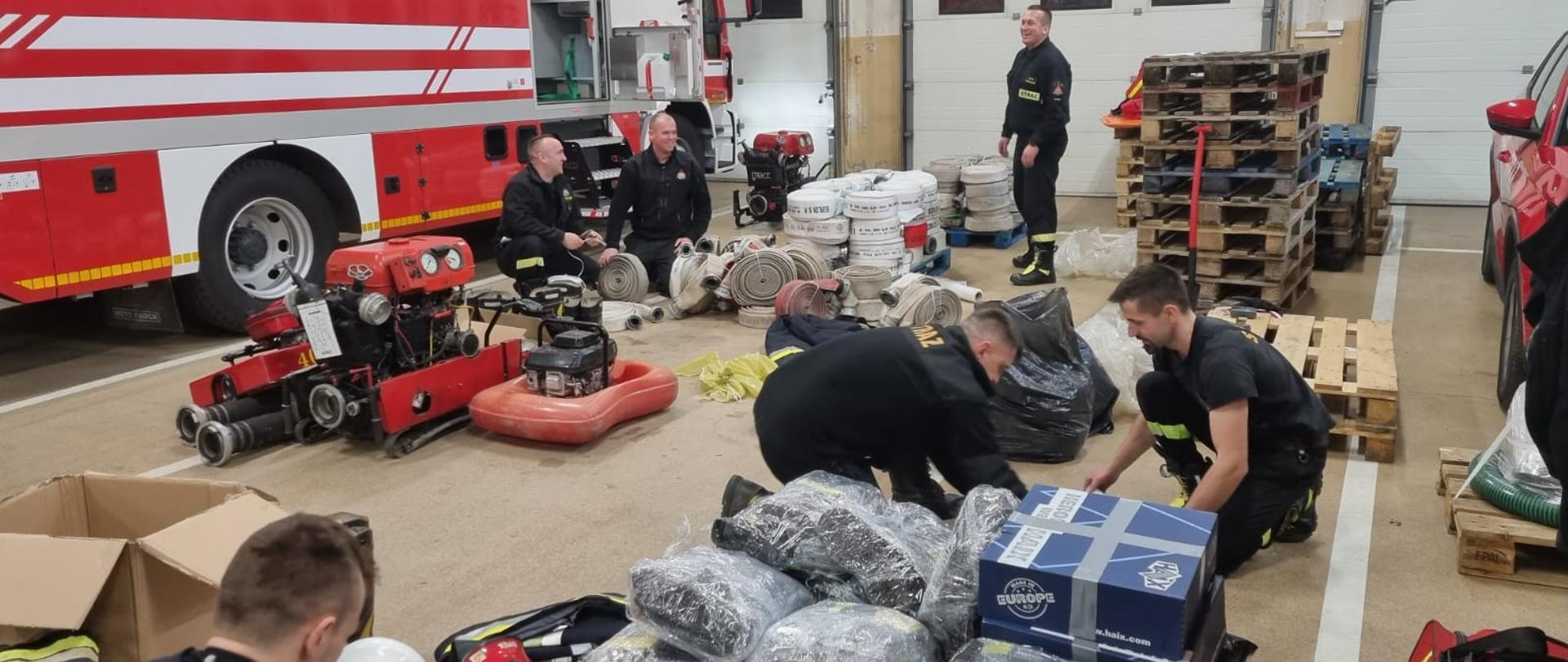Zdjęcie przedstawia strażaków pakujących zgromadzony sprzęt dla strażaków z Ukrainy