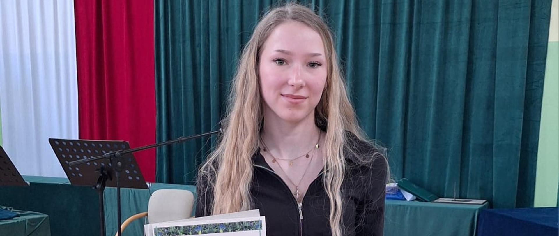 Uczennica ZSCKR ze zdjęciem i dyplomem 