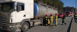 Zatrzymana ciężarówka do kontroli drogowej przez ITD i strażacy zabezpieczający wyciek oleju hydraulicznego z cysterny.
