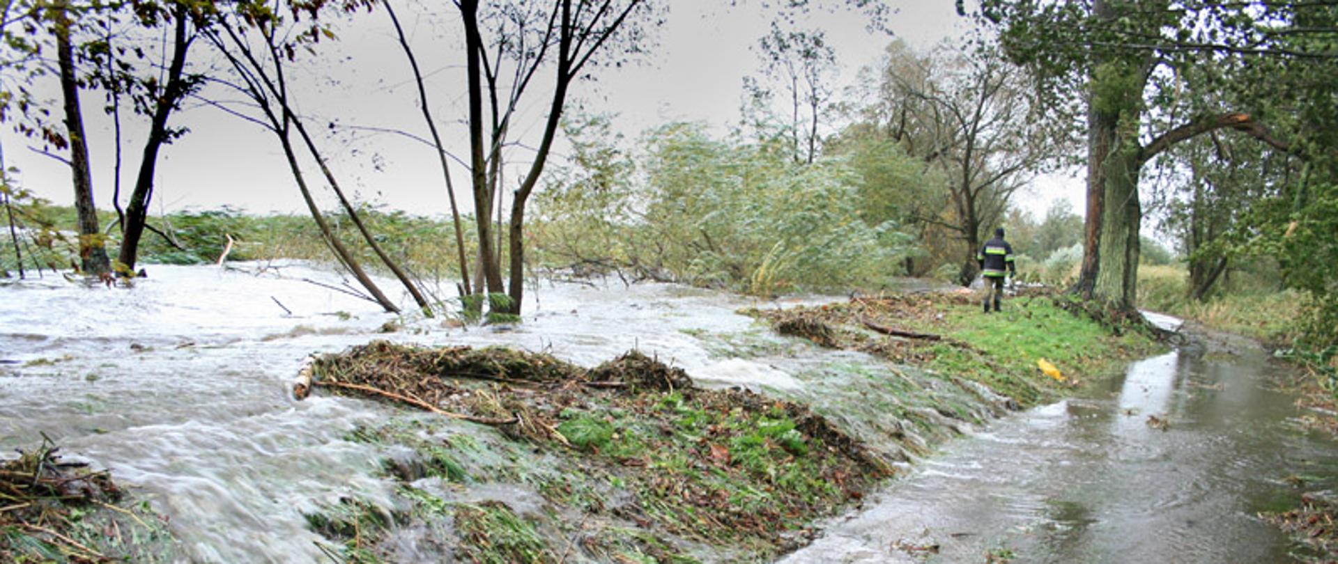 Przelewająca się woda przez wał przeciwpowodziowy