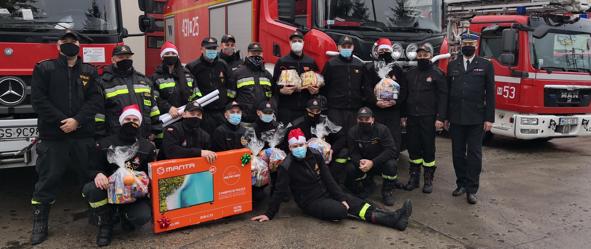 Zdjęcie przedstawiające strażaków KP PSP Gostynin ze świąteczną paczką 2020