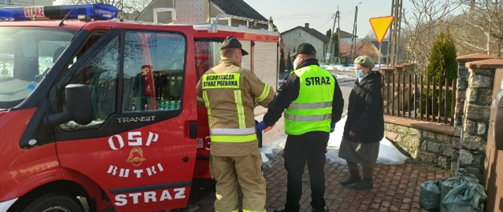 Osoba starsza wsiadająca do samochodu pożarniczego w celu dojechania do punktu szczepień przeciw COVID 19