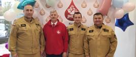 bryg. Marek Szymanek, Prezes klubu Jednostka HDK Krzysztof Roguski, mł. asp. Rafał Łyszkowski ikpt. Rafał Antos na tle ścianki z balonami i logo klubu Jednostka HDK po oddaniu krwi 