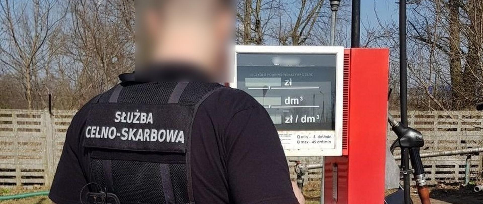 Funkcjonariusz KAS stoi przy dystrybutorze paliwa