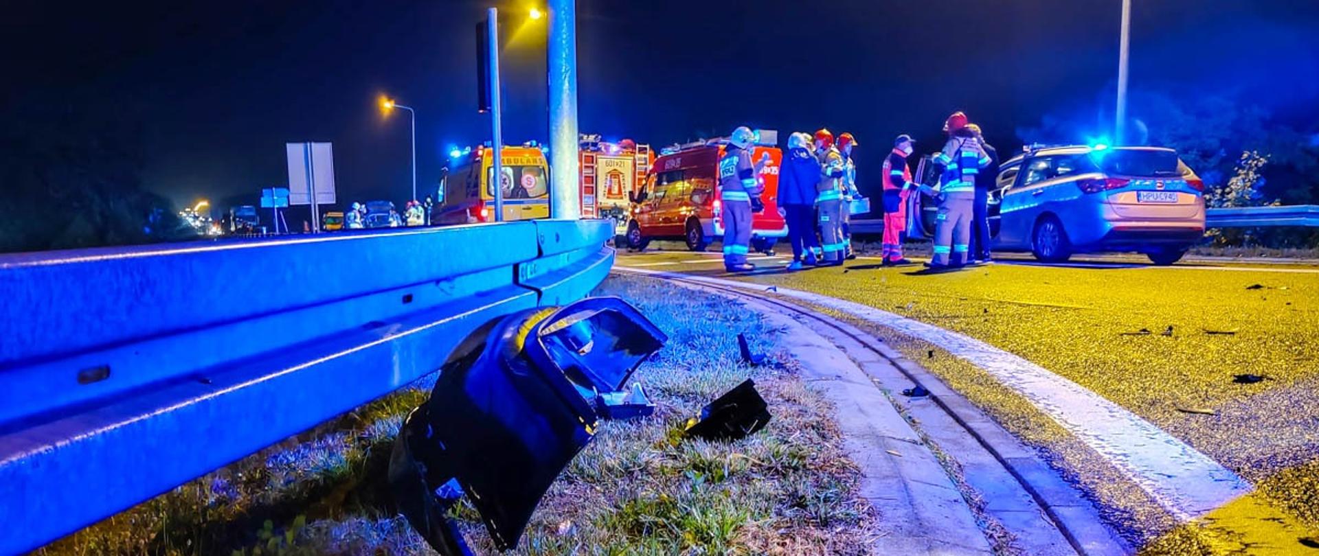 Na zdjęciu służby będące na miejscu wypadku pojazdy JOP Policji i ZRM przy barierce na jezdni urwany zderzak pojazdu