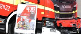 Zdjęcie przedstawia plakat akcji "Bitwa o Remizy 2023". W tle samochody pożarnicze.