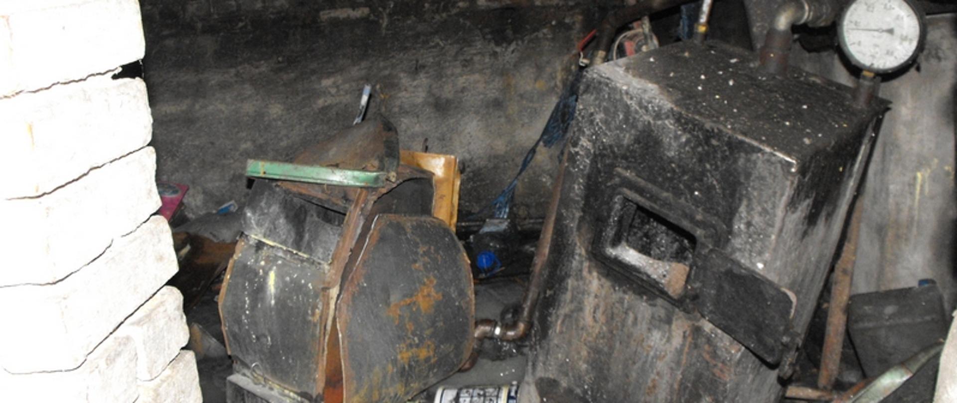 Zdjęcie przedstawia spalone pomieszczenie i uszkodzony piec