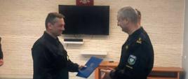 Na zdjęciu widać Komendanta Powiatowego PSP wręczającego decyzję o zakończeniu stażu st. str. Przemysławowi Dylewskiemu.