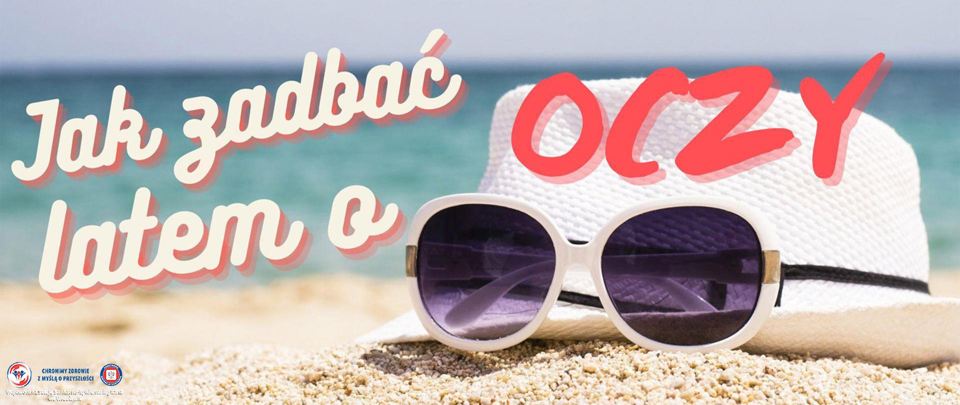 Kapelusz przeciwsłoneczny oraz okulary przeciwsłoneczne leżące na plaży