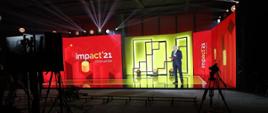 Wicepremier i minister rozwoju, pracy i technologii Jarosław Gowin podczas otwarcia wiosennej edycji Impact"21, z tyłu za jego placami logo Impact'21 na czerwonym i żółtym tle
