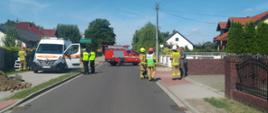 Droga zablokowana pojazdem pożarniczym. Na drodze stoją strażacy, pogotowie gazowe i policjanci.