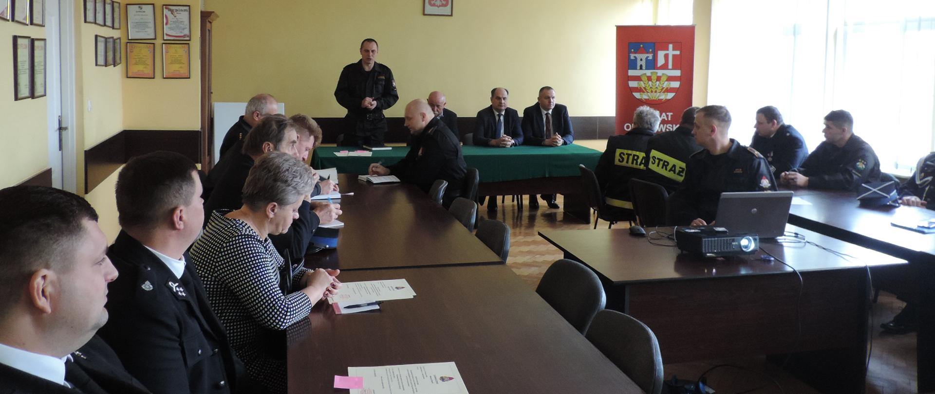 Zdjęcie przedstawia druhów OSP siedzących przy stołach. 