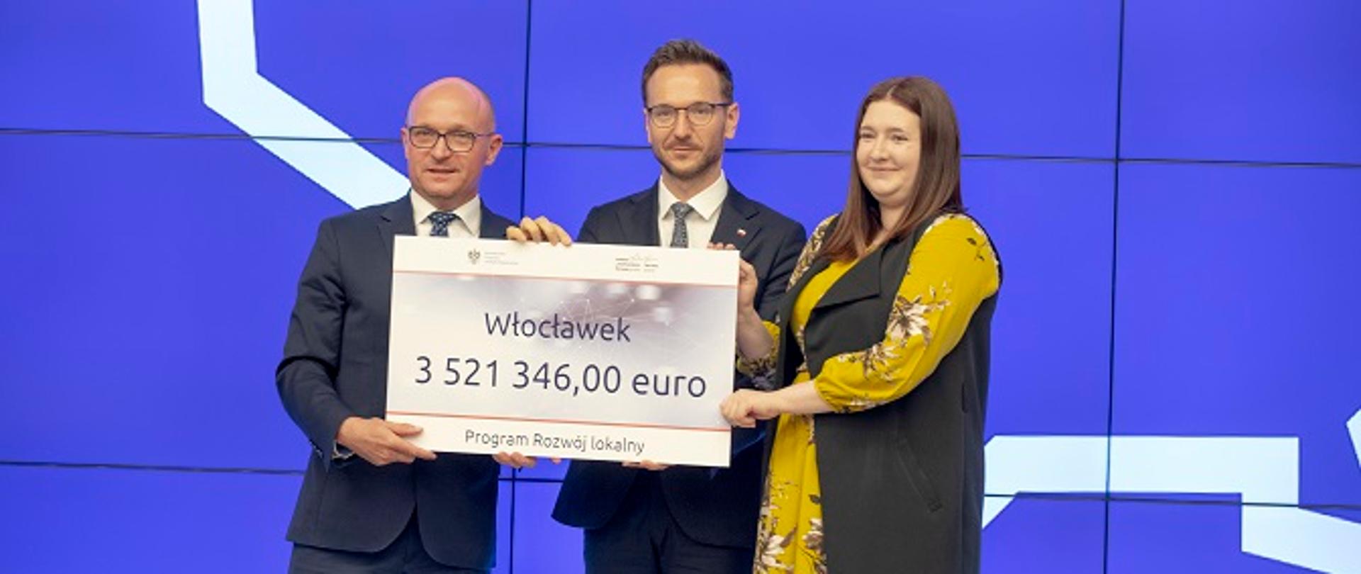 Na zdjęciu od lewej prezydent Włocławka Marek Wojtkowski, wiceminister Waldemar Buda, wiceminister Anna Gembicka. Wszyscy trzymają w rękach planszę z napisem Włocławek, 3 521 346,00 euro.
