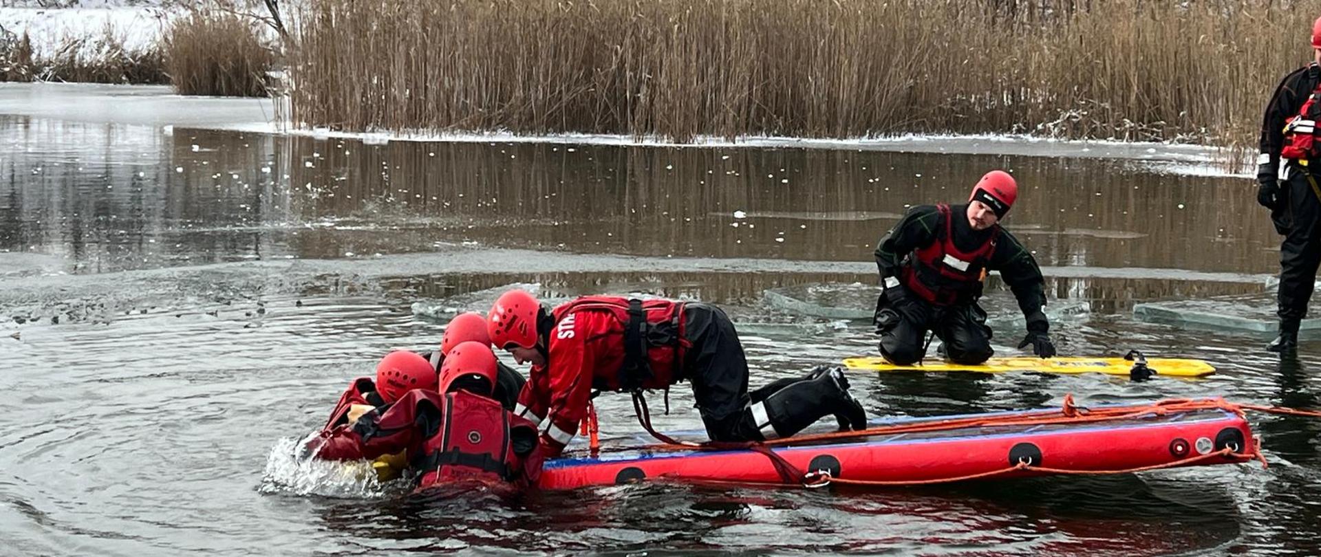 Ćwiczenia z zakresu ratownictwa lodowego, strażacy ćwiczą podejmowanie osoby poszkodowanej z przerębla