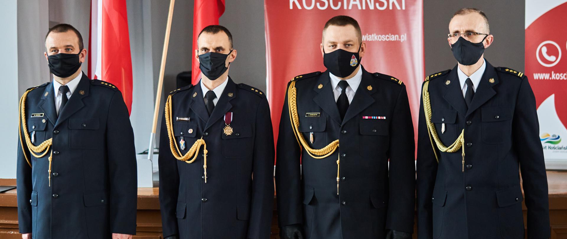 czterech strażaków stojących w maseczkach i mundurach wyjściowych, zdjecie grupowe