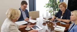 Wiceminister Marzena Machałek siedzi przy stole podczas spotkania z przedstawicielami KGHM Polska Miedź S.A.