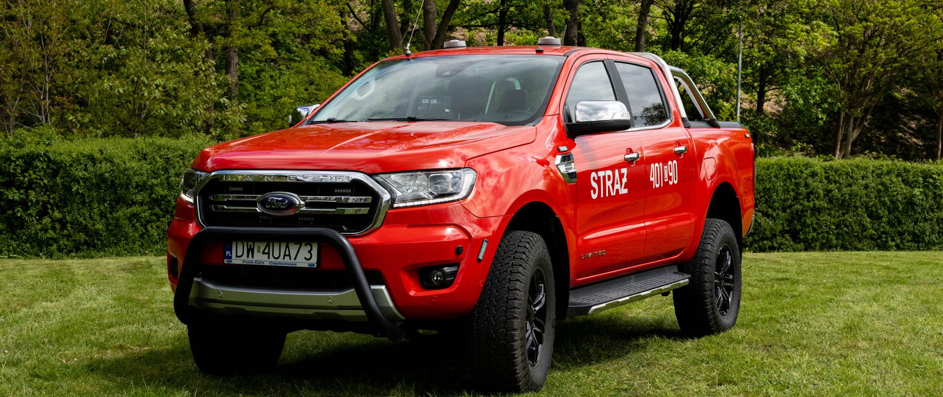 Czerwony, uterenowiony pickup Ford Ranger z podwójną kabiną i czarnym orurowaniem z przodu (bullbar). Na przednich drzwiach umieszczono biały napis „STRAŻ” a na tylnych numer operacyjny „401[D]90”. Pojazd ma terenowe opony, czarne felgi i stoi na zielonym trawniku.