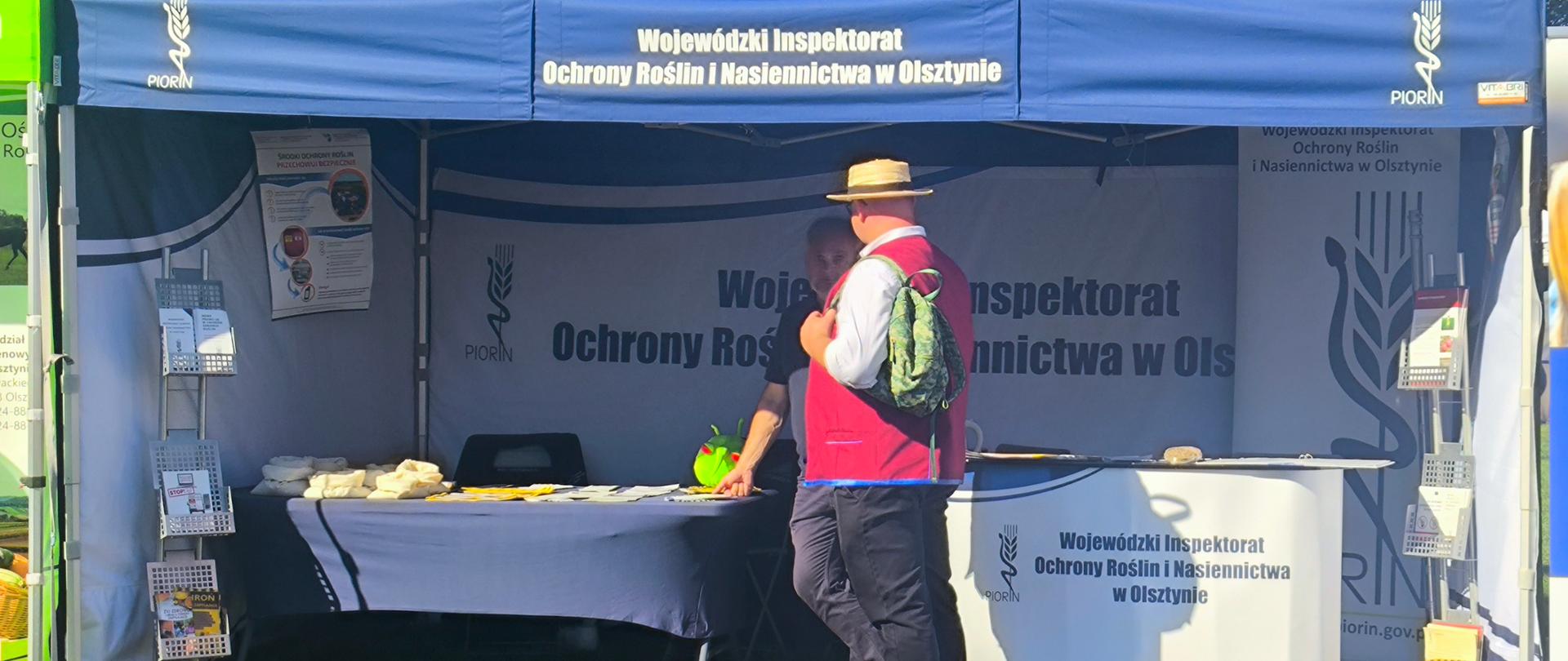 stoisko informacyjne WIORiN przed stoi mężczyzna i rozmawia z inspektorem