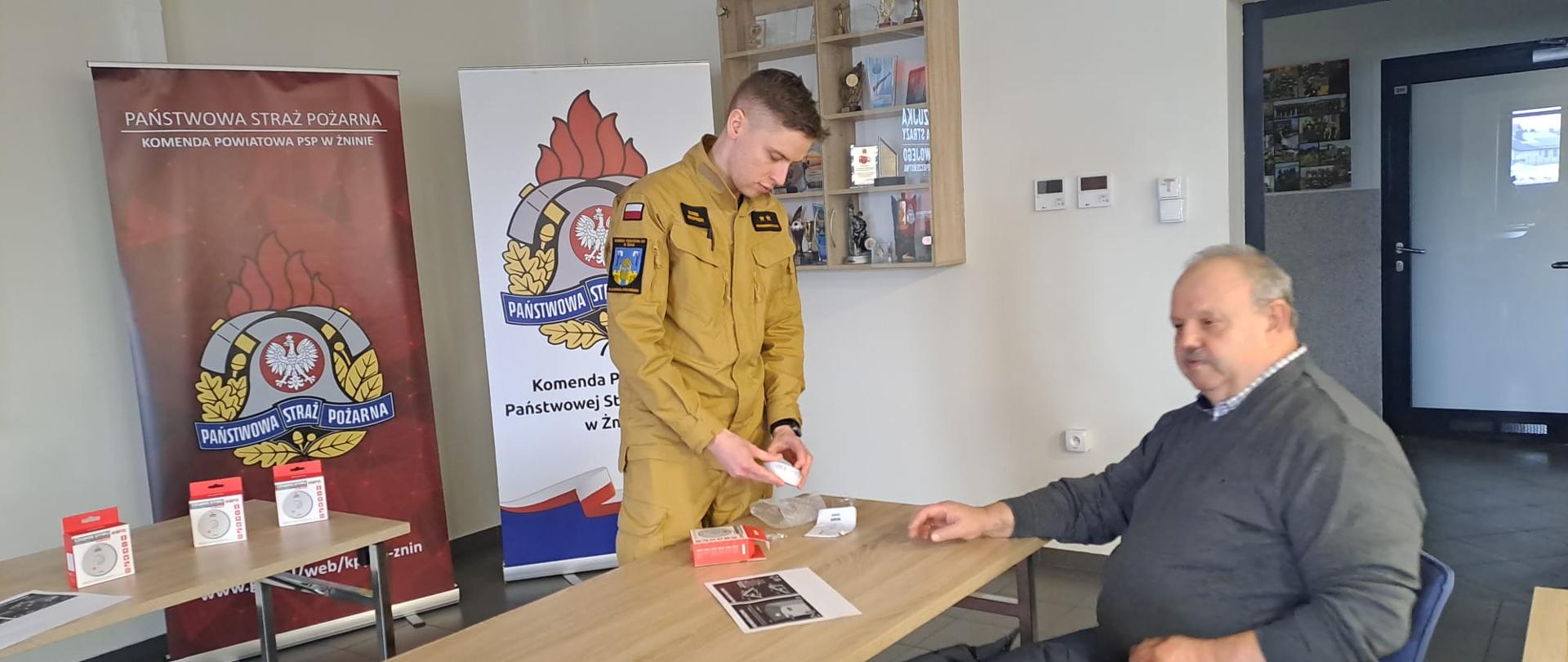 Na zdjęciu funkcjonariusz prezentujący czujkę.