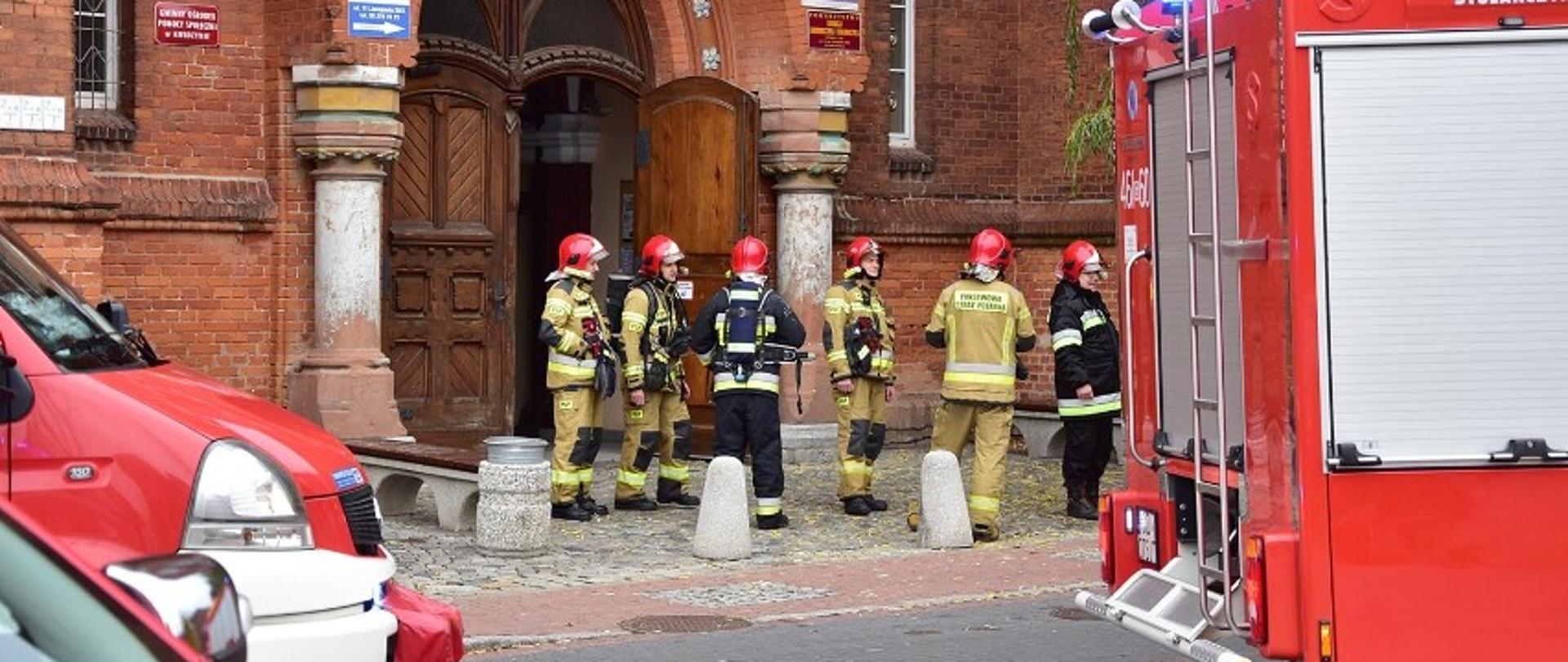 Pojazdy i strażacy przed budynkiem przy ul. 11-go Listopada 27 w Kwidzynie