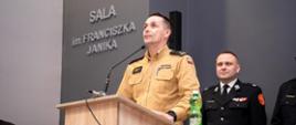 Zajęcie przedstawia stojącego przy mównicy i przemawiającego komendanta powiatowego Państwowej Straży Pożarnej w Gorlicach podczas eliminacji powiatowych Ogólnopolskiego Turnieju Wiedzy Pożarniczej w Gorlicach 