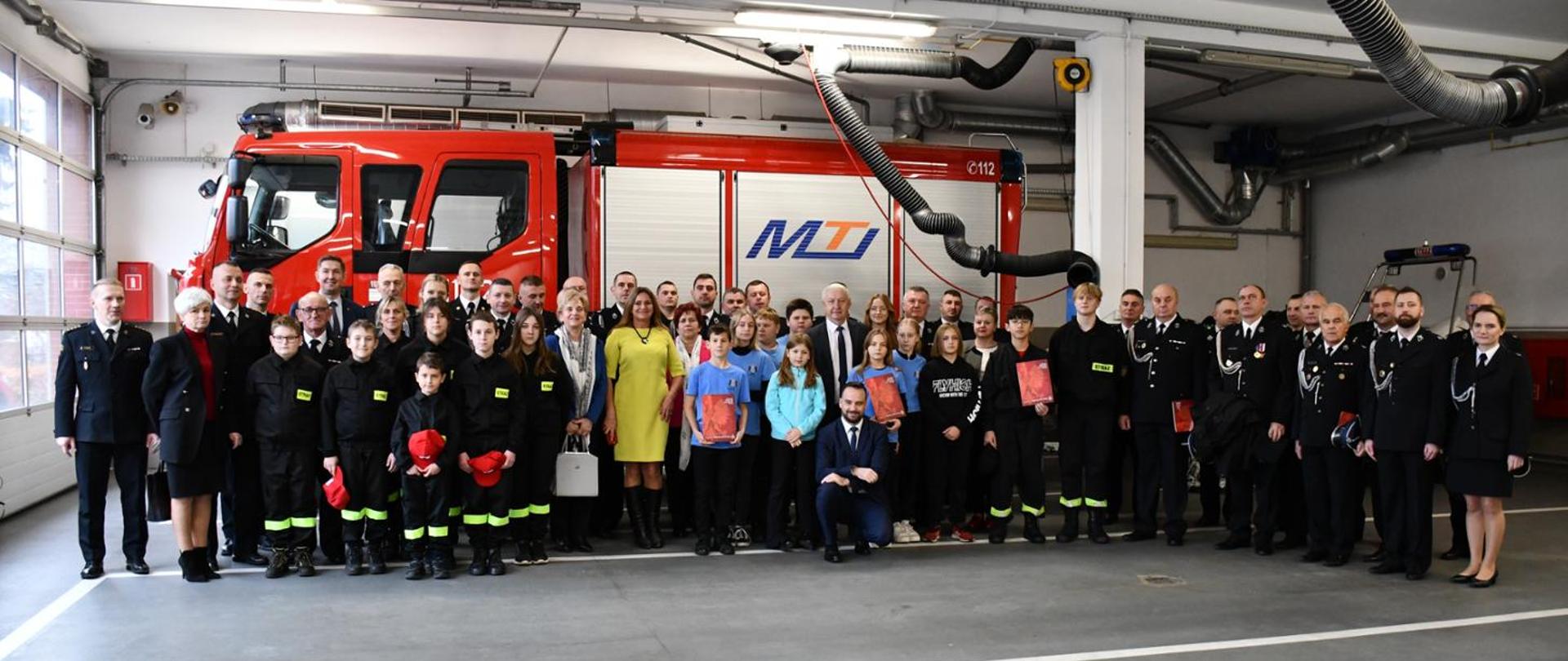 Wspólne grupowe zdjęcie strażaków PSP i OSP, zaproszonych gości oraz młodzieżowych drużyn pożarniczych.