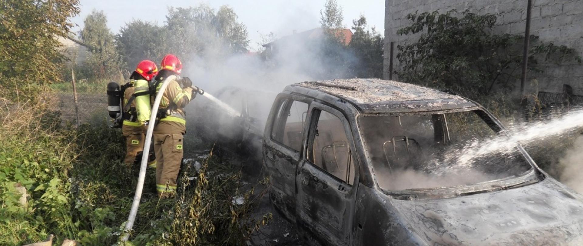 Strażacy prowadzący działania gaśnicze palących się pojazdów