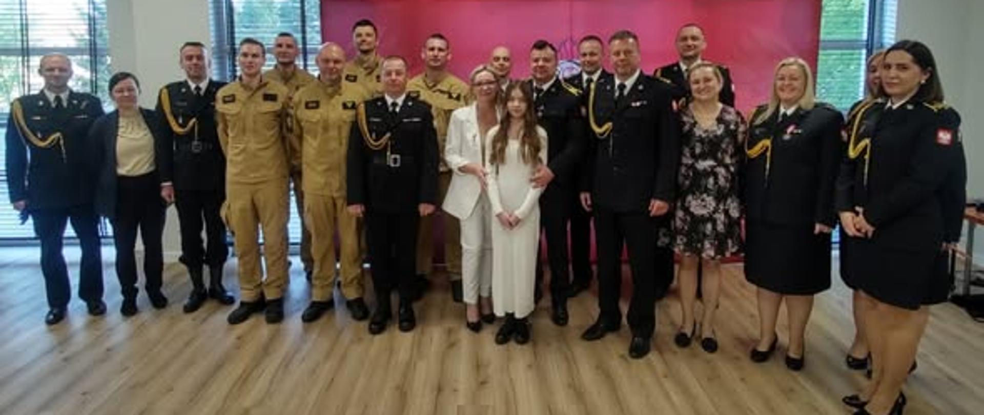 Funkcjonariusz wraz ze strażakami i rodziną