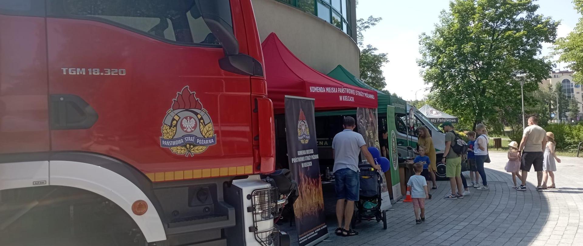 Zdjęcie przedstawia stoisko Komendy Miejskiej Państwowej Straży Pożarnej w Kielcach oraz uczestników festynu.