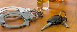 Kajdanki, alkohol i kluczyki na stole
