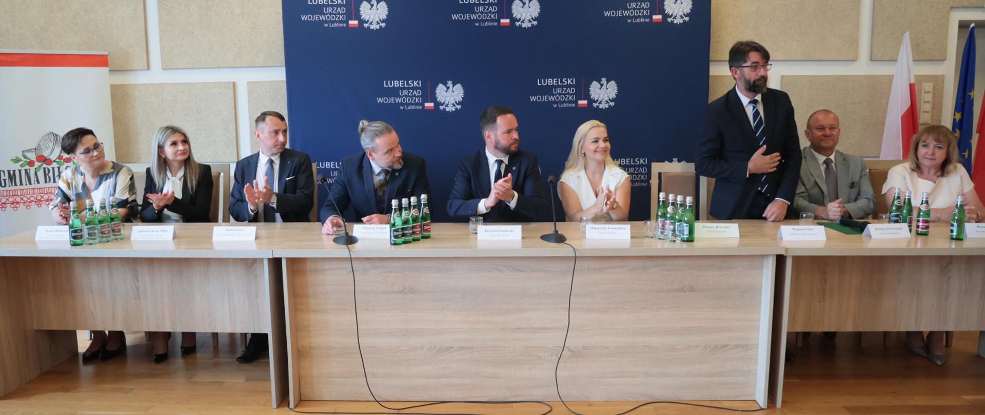 Oficjalne otwarcie Punktu Paszportowego w Biłgoraju. Przy stole prezydialnym zasiadają m.in. wojewoda lubelski Krzysztof Komorski (w centrum, w ciemnym garniturze) oraz wicewojewoda Wojciech Wołoch (czwarty od lewej, w ciemnym garniturze), a także przedstawiciele lokalnych władz i zaproszeni goście.
