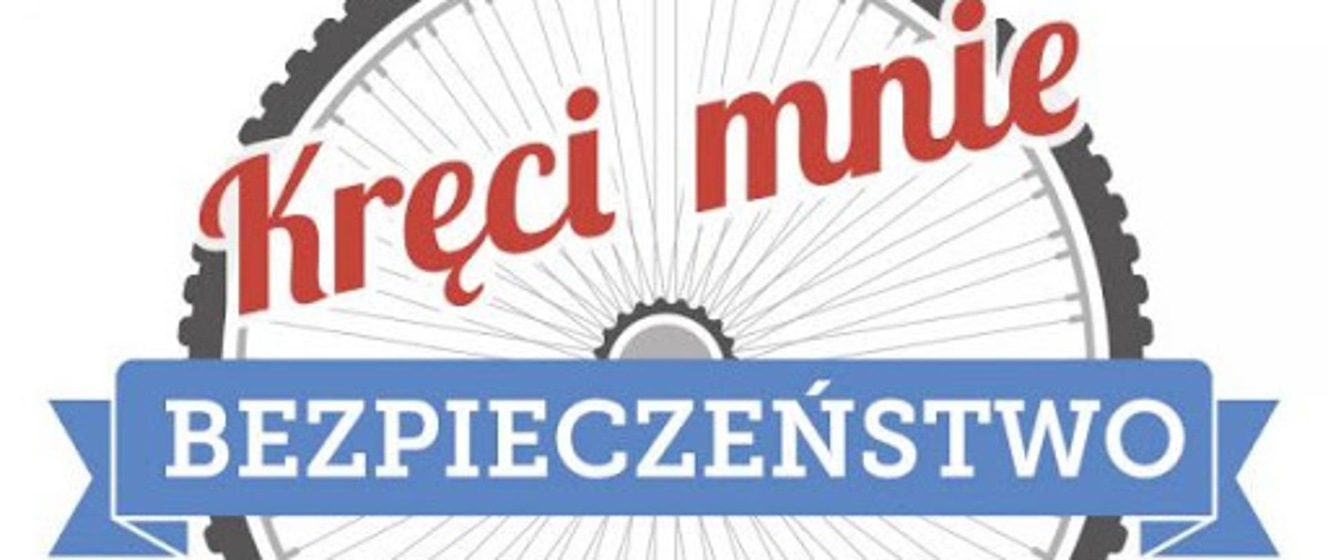 Zdjęcie pokazuje logo kampanii kręci mnie bezpieczeństwo Ministra Spraw Wewnętrznych i Administracji. Logo składa się z koła rowerowego, na którym widnieje napis Kręci mnie bezpieczeństwo w kolorach czerwony i niebieski.