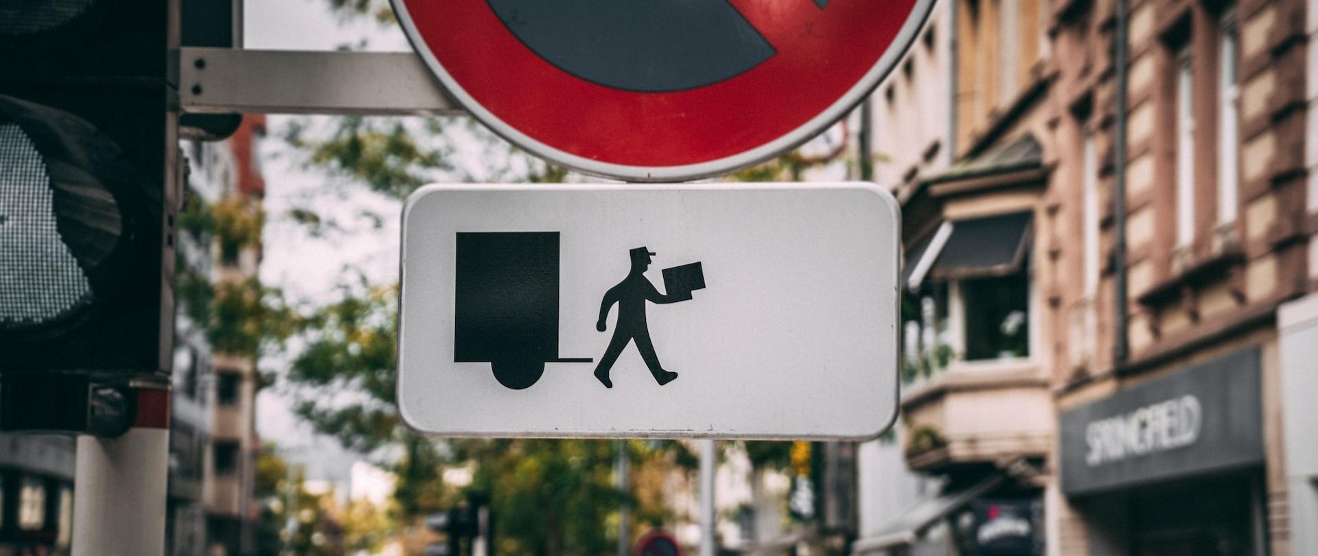 Znak drogowy przedstawiający postać w czapce z paczką