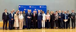 grupa oficjeli stoi na scenie, pozują do zdjęcia 