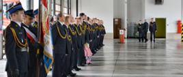 Funkcjonariusze PSP w ubraniach galowych stoją w garażu na Jednostce Ratowniczo - Gaśniczej nr 2