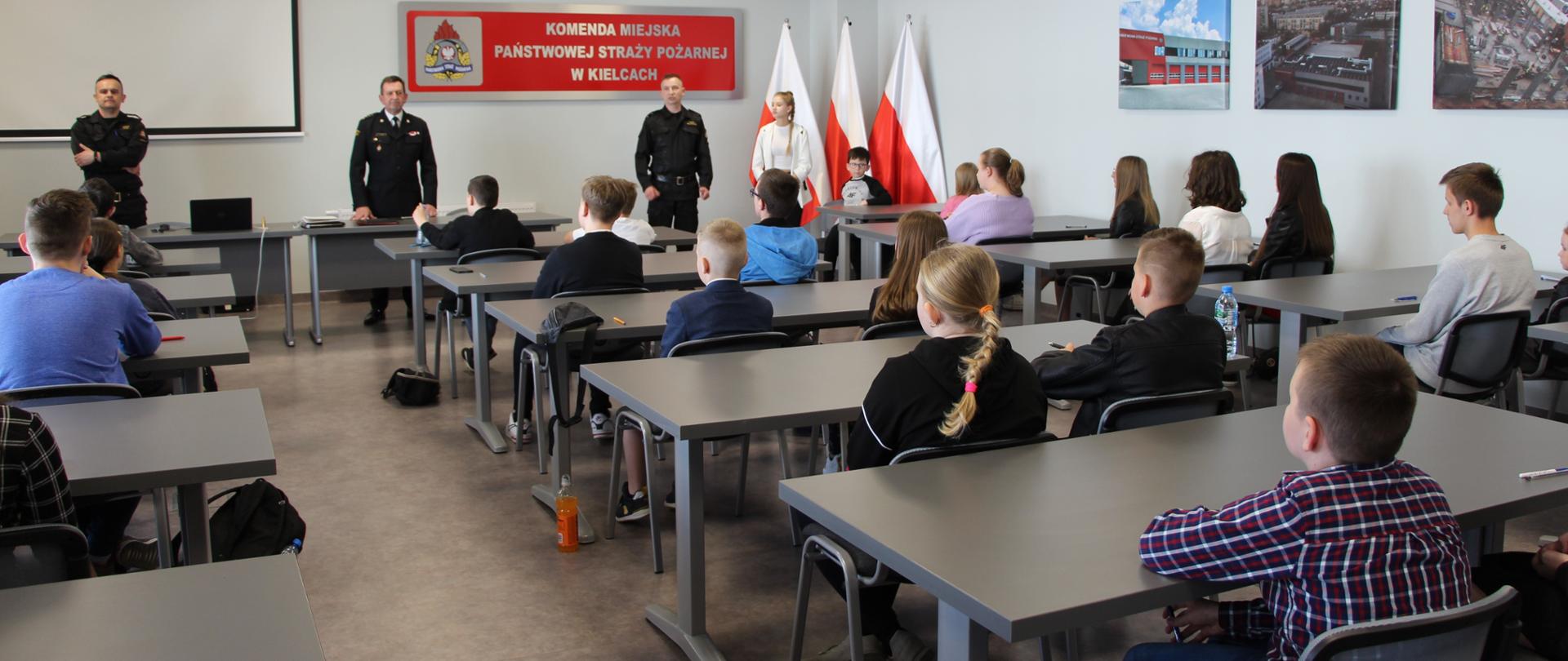 Na zdjęciu przedstawiono uczestników eliminacji powiatowych Ogólnopolskiego Turnieju Wieży Pożarniczej. W głębi fotografii w mundurach stoją od lewej: st. asp. Tomasz Zając, komendant miejski Państwowej Straży Pożarnej w Kielcach st. bryg Sławomir Karwat i st. kpt. Paweł Wilczkowski.
