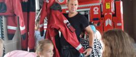 Strażak omawia i pokazuje dzieciom sprzęt pożarniczy